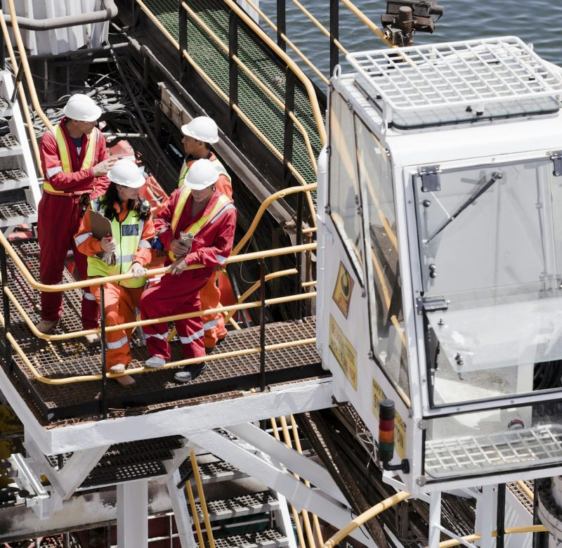 Industrial workers in a safety meeting on an offshore platform.